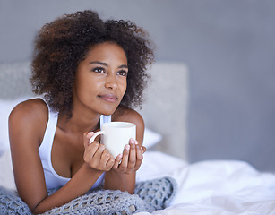 Image showing Woman, happy and relax in bedroom with coffee mug, wellness and espresso on morning vacation on home. Young lady, inspiration and cup of tea on lazy weekend, break and peace on bed in cozy apartment