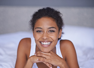 Image showing Woman, happy and relax in bedroom in portrait, wellness and confident on morning vacation on home. Young lady, smile face and healthy on break on lazy weekend, pyjamas and calm on bed in apartment