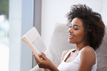 Image showing Happy, black woman and reading with book on couch for novel, story or literature in living room at home. African female person with smile for information, news or interesting knowledge at the house