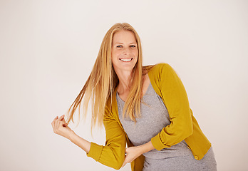 Image showing Smile, fashion and portrait of woman in studio with casual, trendy and cool outfit with confidence. Happy, attractive and female person playing with hair for cardigan style by white background.
