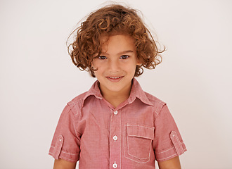 Image showing Smile, fashion and boy child in studio with casual, trendy and cool shirt for outfit with curly hair. Happy, cute and portrait of adorable young kid model with style isolated by white background.