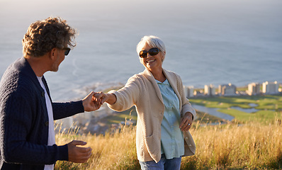 Image showing Happy, vacation and couple outdoor in dance on hill or mountain in Cape Town and holding hands with love. Mature, people and embrace with kindness on holiday adventure in nature and relax together