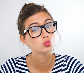 Image showing Portrait, woman and pout with glasses, student and person on a white studio background. Face, model and girl with lipstick and flirt with romance gesture and eyewear with humor and vision