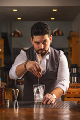 Image showing Confident bartender crafting a cocktail