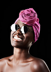 Image showing Face, turban and smile with black woman in studio isolated on dark background for heritage. Fashion, model and sunglasses with confident African person in trendy headwear for traditional style