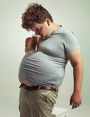 Image showing Obese, weight gain and alcohol for man in studio with drink for unhealthy habit, plus size and joke. Overweight person with glass on fat stomach for balance, comedy and humor for lager and comic