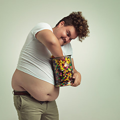 Image showing Candy, jar and crazy man in studio for luxury snacks, sweets and dessert in jar. Comic, facial expression and overweight, isolated and plus size person with glass for unhealthy diet on background