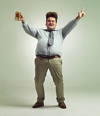 Image showing Happy man, portrait and celebration with beer for party or obesity on a studio background. Young male person or plus size model with glass, mug or alcohol in satisfaction for booze on mockup space