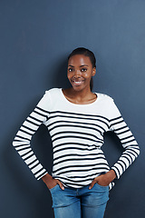 Image showing Black woman, happy and portrait in studio with confidence and trendy fashion by blue background. African model, positive or face with hands in pocket, calm or pride in funky jeans for gen z aesthetic