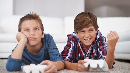 Image showing Happy, children and winning a video game in home with friends in online competition for esports challenge. Excited, kid and celebration of gaming victory in contest with sad boy on floor of lounge