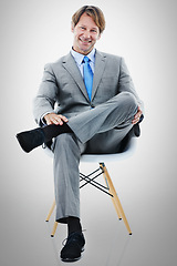 Image showing Businessman, portrait and sitting with chair in relax for interview or career opportunity on a gray studio background. Man or employee with smile in fashion, style or job for startup on mockup space