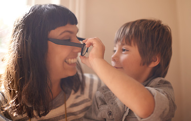 Image showing Remove glasses, mother and son with smile, funny and family with happiness and cheerful in a lounge. Single parent, mama and kid with childhood and take off eyewear with joy and humor with laughing