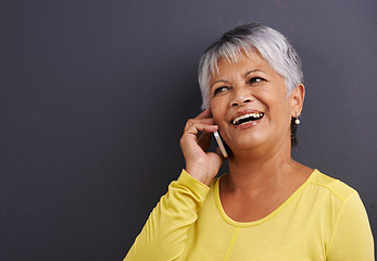 Image showing Happy, phone call and senior woman in studio for communication, good news or gossip. Contact, mockup and elderly female person on mobile conversation with cellphone for talking by black background.