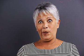 Image showing Surprise, portrait and senior woman in studio with crazy, silly or crazy facial expression for comedy. Shock, comic and elderly female person with wow, omg or wtf face isolated by gray background.