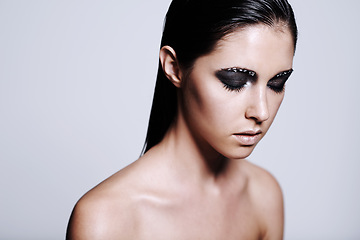 Image showing Woman, face and beauty with makeup, eyeshadow or cosmetics on a gray studio background. Young female person, brunette or model with gothic style in skincare, salon or facial treatment on mockup space