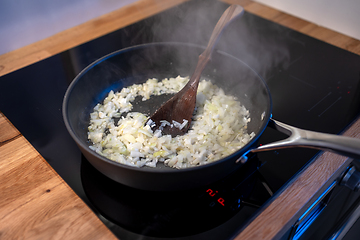 Image showing onions preparing on cooking pan 