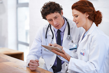 Image showing Doctors, man and woman on tablet in hospital for team, planning and review for medical results. Medic employees, people and digital touchscreen in clinic for collaboration with telehealth services