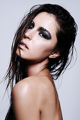 Image showing Woman, beauty and portrait with makeup, eyeshadow or fashion in skincare on a gray studio background. Face of female person, brunette or model with dark gothic cosmetics, style or facial treatment