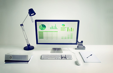 Image showing Workspace, computer screen and notebook in room with light for remote work, infographics or data analytics. Workplace, monitor and documents on desk with keyboard for financial career and statistics