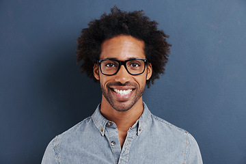 Image showing Happy man, portrait and glasses with frame in studio and curly afro in trendy eyewear for optometry. Model, face and consultant in fashion spectacles, vision and smile for eyecare by blue background