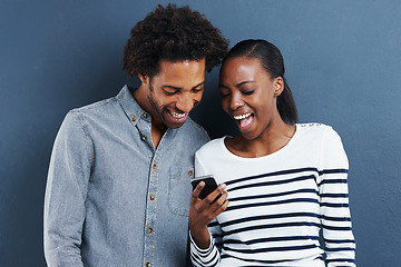 Image showing Black couple, funny and smartphone with meme, smile and social media on a blue studio background. Mockup space, mobile user and man with woman and cellphone with online reading and video with humor