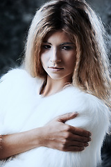 Image showing Woman, winter fashion and confident outdoors, attitude and pride for fur coat or warm clothes. Female person, serious face and closeup of fluffy jacket in nature, forest and trendy or casual outfit