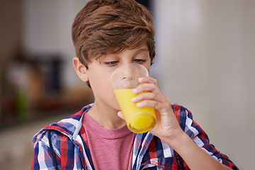 Image showing Kids, kitchen and boy drinking orange juice from glass in morning for diet, health or nutrition. Breakfast, children and cup with young teen in apartment to enjoy fresh beverage for development