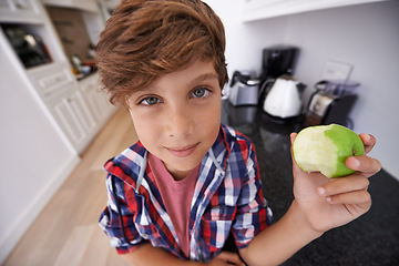 Image showing Portrait, apple and children with boy in kitchen of home for health, organic diet or nutrition. Face, fruit and confident young teen kid eating green food in apartment for growth or development