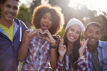 Image showing Portrait, smile and diverse friends in nature, outdoors or garden with excited expression. Social, joy or happy with hand heart emoji from group of student, summer and sunset with lens flare outside