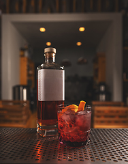 Image showing Artisanal cocktail on bar counter with whiskey bottle