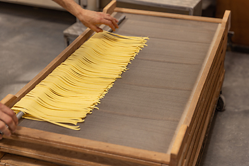 Image showing Fresh pasta drying on wooden rack