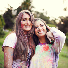 Image showing Color, festival and portrait of women with powder together for fun, Holi and outdoor social in spring, nature and joy. Smile, paint splash and celebration in park with friends, trees and happy event