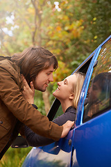 Image showing Travel, window and couple kiss in car for greeting, goodbye and love on journey, leaving and commute. Transport, driving and man and woman in vehicle for bonding, relationship or embrace on road trip