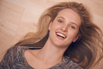 Image showing Happy, portrait and woman on a floor with confidence, positive attitude or feel good mood from above. Face, smile and female person relax in a living room on day off, weekend or vacation in her home