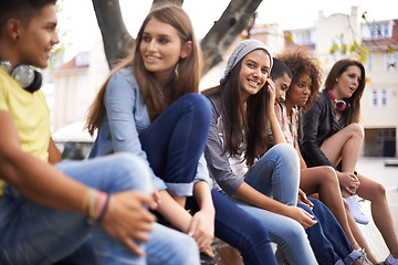 Image showing Happy, portrait and girl with students in city for bonding, talking and sitting together. Smile, diversity and young female teenager with group of gen z friends in conversation in urban town.