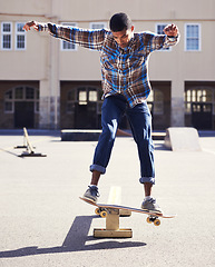 Image showing Man, skateboard and balance with riding at skatepark, sport and energy with skill, stunt and recreation outdoor. Skateboarder, technique and trick, action with training and workout for exercise