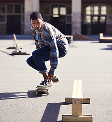 Image showing Man, skateboard and riding at urban skatepark, sports and energy with skill, stunt and recreation activity outdoor. Skateboarder, technique and trick, training and workout for balance and exercise