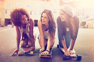 Image showing Skatepark, laugh and friends in street for balance, hobby or competition in city. Skater, lens flare and diverse group of women with skateboard for training, exercise or happiness in outdoor activity