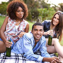 Image showing Portrait, happy friends and picnic in outdoor park for weekend break, bonding and adventure in nature. Smile, beer and face of group of diverse people on blanket for travel, vacation or fresh air