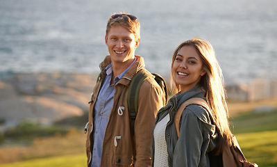 Image showing Love, portrait and happy couple on hike with ocean, sunset for tropical holiday adventure, relax and bonding together. Smile, man and woman on romantic date with beach, nature and grass on vacation