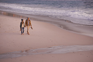 Image showing Couple, holding hands and love for walking on shore, ocean waves and peace for romance in relationship. People, beach and security in marriage, sea and travel together on vacation or holiday for date