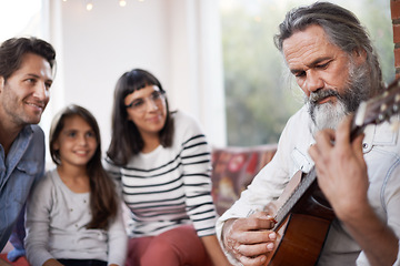 Image showing Mature man, music and playing guitar for family at home, relaxing and enjoying together on sofa. Performance, parents and child with grandfather in living room for entertainment with instrument