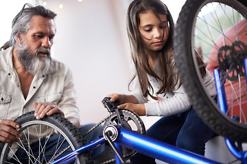 Image showing Father, child and bicycle for fixing chain as maintenance in garage for bonding together, transportation or teamwork. Mature man, daughter and equipment for bike repair or gear help, wheel or tyre