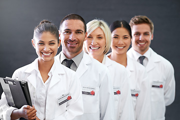 Image showing Smile, portrait and row of doctors in studio for health insurance, medicine and trust in hospital. Confidence, group and diversity with men, women and professional medical team on grey background