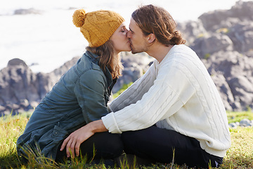 Image showing Affection, couple and kissing in nature or outdoor on grass, hilltop and scenery or passionate people. Love, care and romantic date or winter vacation, holiday and relationship together in Sweden