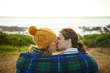 Image showing Happy couple, kiss and bonding together in nature, blanket and romantic getaway with camping by ocean. Man, woman or love on vacation on weekend break, cape town or travel adventure by sea in sunset