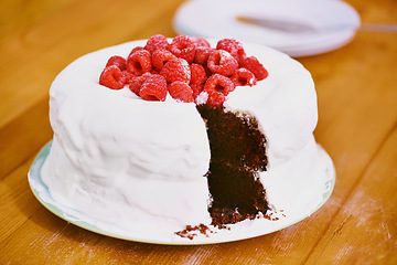 Image showing Chocolate, dessert and blackforest cake for bakery, raspberries and sweet snack for eating. Fruit, icing and plate for display on table in restaurant, creamy and baked confection with berries