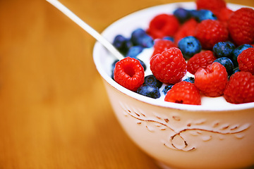 Image showing Closeup, berries and bowl with yogurt, raspberry and blueberry for organic snack. Food, cuisine and breakfast for health, wellness and diet for morning nutrition and antioxidant wellbeing in studio