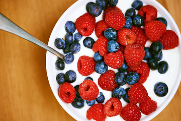 Image showing High angle, berries and nutrition with yogurt, raspberry and blueberry for organic snack. Food, cuisine and breakfast for health, wellness and diet for morning bowl or antioxidant wellbeing in studio