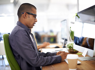 Image showing Computer, typing and businessman in office, employee and writing for work project. Eyewear, desk and technology with internet for design by graphic designer, keyboard and online in workspace